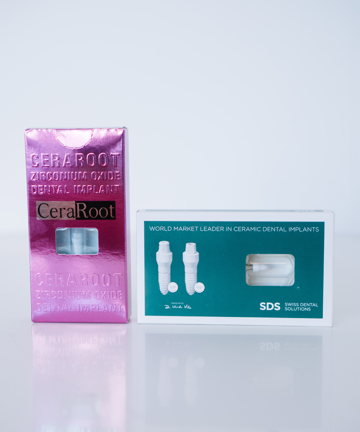 Product boxes for CeraRoot Zirconium Oxide and SDS Swiss Dental Solutions ceramic dental implants, showcasing metal-free alternatives for holistic tooth replacement.
