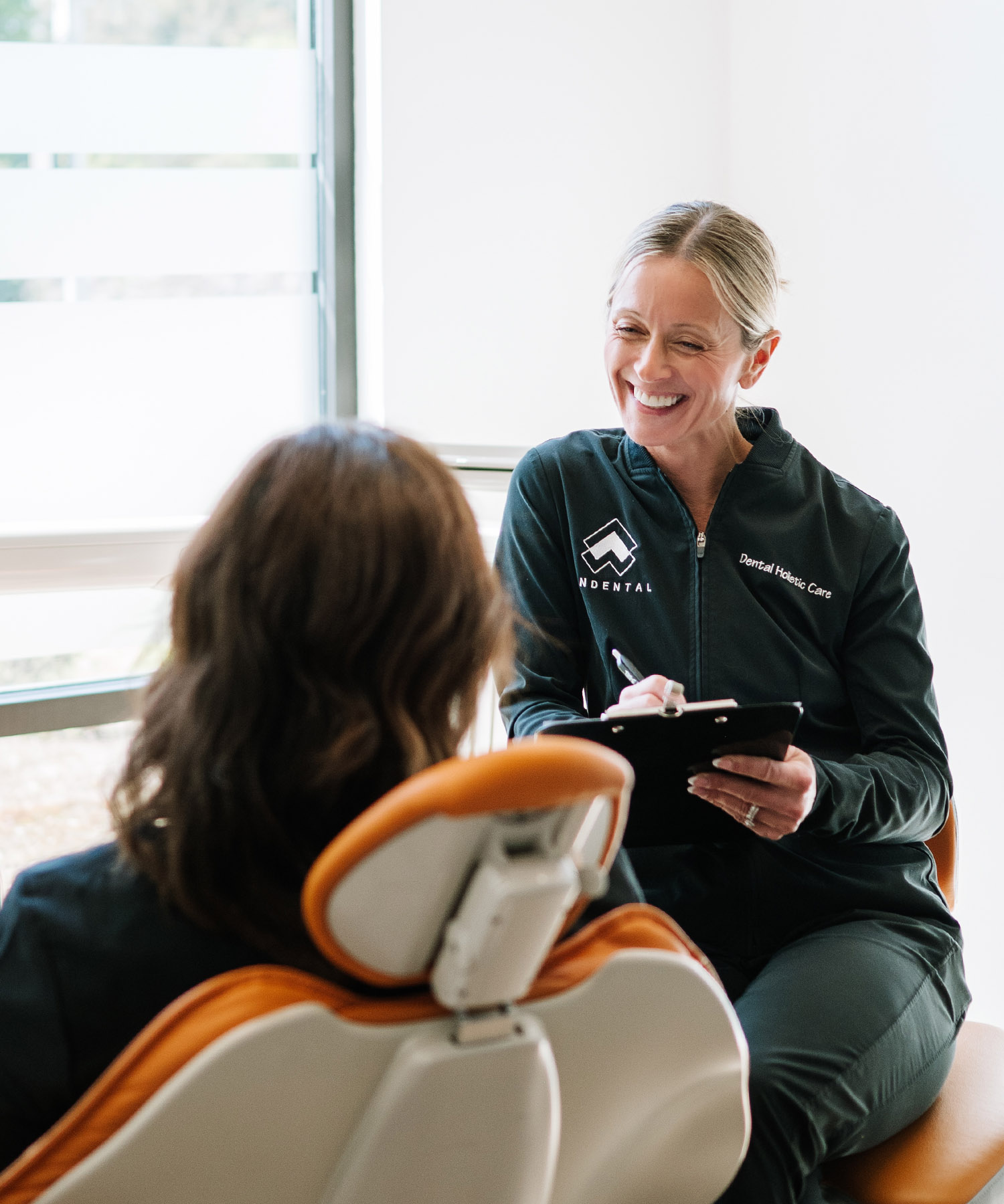 Jennifer Senderkiewicz smiles with a patient while discussing mineral health assessment and wellness coaching.