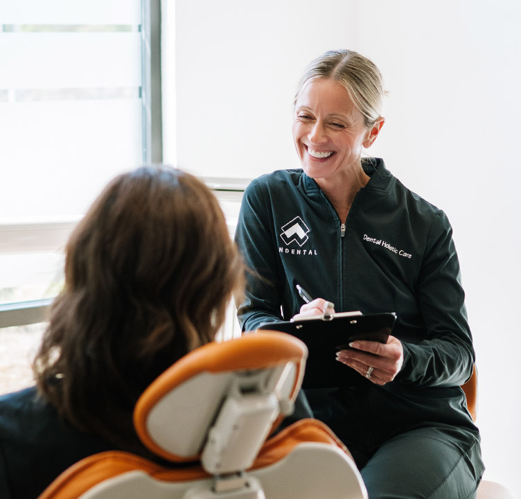 Jennifer Senderkiewicz smiles with a patient while discussing mineral health assessment and wellness coaching.